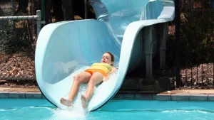 Ilustrasi anak sedang berada di seluncuran kolam renang. Ini penjelasan fitur tersebut.