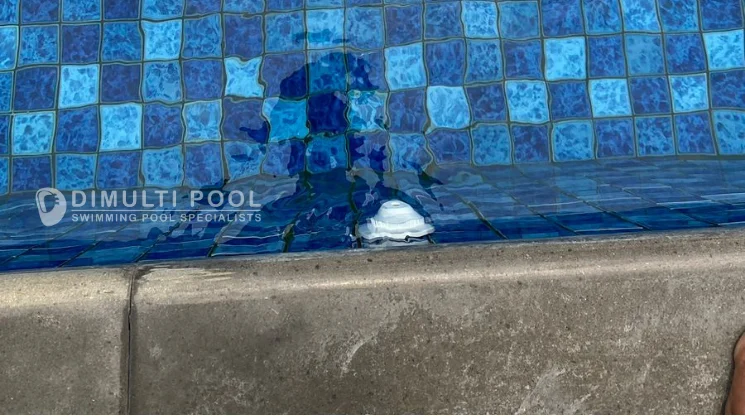 Inlet fitting yang terpasang di dinding kolam renang.